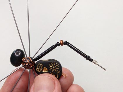 Bent spider leg with a clip on the end to prevent the beads from falling off